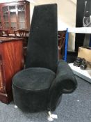 A contemporary high back armchair in black fabric