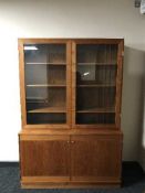 A mid twentieth century teak glazed door bookcase with cupboard beneath