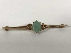 A 9ct gold and jade bar brooch