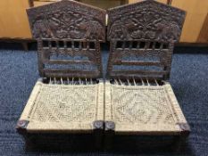 A pair of heavily carved hardwood folding tribal chairs depicting elephants