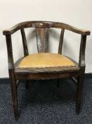 An early 20th century oak horseshoe armchair with studded leather seat