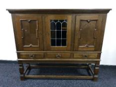 A continental oak triple door sideboard fitted with three drawers