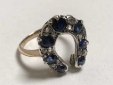 An antique horseshoe ring set with diamonds and sapphires