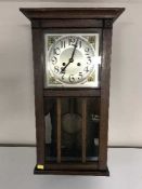 A late Victorian oak wall clock with pendulum and key
