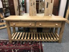 A reclaimed pine two drawer farmhouse work table with plate rack below