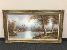 A contemporary large gilt framed oil painting depicting a cottage by a river, oil on canvas,