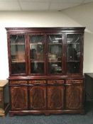 An inlaid four door bookcase fitted cupboards beneath