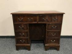 A Georgian style mahogany lady's knee hole desk with tooled leather top