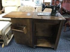 A Federation treadle sewing machine in walnut cabinet