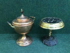 An antique copper and brass tea urn on brass trivet