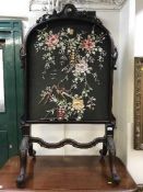 A Victorian heavily carved mahogany firescreen