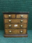 A miniature Victorian oak five drawer chest
