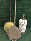 Two copper and brass bed warming pans together with a pottery table lamp on mahogany base