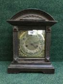 A late nineteenth century oak fourteen day strike mantle clock with brass face