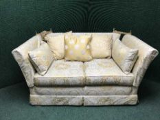 A three piece lounge suite upholstered in golden floral fabric comprising of three seater settee,