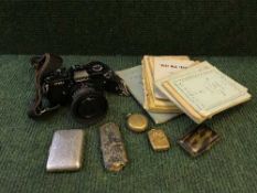 A basket containing Yashica FR1 camera, tortoiseshell cigarette case, vesta box,