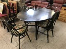 A circular Ercol drop leaf table together with five chairs