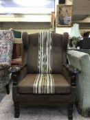 An early twentieth century oak framed wing backed armchair