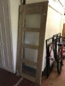 A contemporary interior door inset with four glass panels