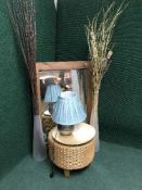 A contemporary pine framed mirror, two large glass vases containing sticks, wicker footsool,