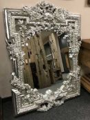 An ornate silvered floral mirror