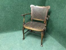 An antique mahogany child's bergere armchair