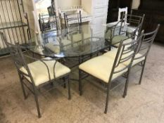 A heavy metal based glass topped table together with six chairs