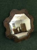 An early twentieth century shaped oak framed bevelled mirror