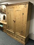A pine double door wardrobe fitted with two drawers