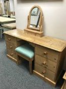 A pine kneehole dressing table with mirror and stool