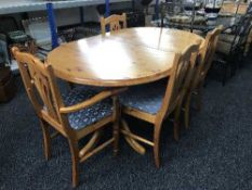 An oval pine extending dining table and four chairs