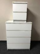 A white four drawer chest and matching bedside chest
