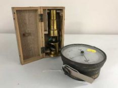 A brass cased circular barometer and miniature brass telescope in fitted wooden box