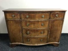 An inlaid serpentine fronted sideboard