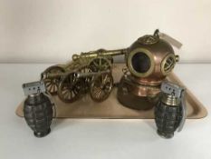 A miniature copper and brass diver's helmet together with three metal cannons and two hand grenade