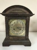 A late nineteenth century oak fourteen day strike mantle clock with brass face