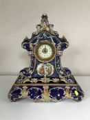 An antique blue and gilt china mantel clock on plinth
