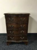 A mahogany serpentine fronted four drawer chest on bracket feet