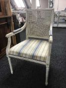 A cream begere back armchair on reeded legs