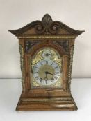 A carved mahogany cased bracket clock with brass dial and mounts