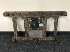 An antique carved oak framed mirrored coat rack