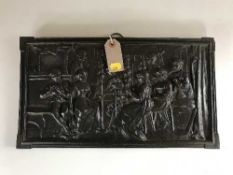 A cast iron embossed plaque depicting figures at work