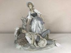A Lladro porcelain group, a lady standing over a man sleeping against a tree stump,