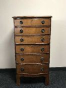 An antique bow-fronted six drawer chest