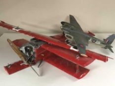 A large model aircraft of a German Fockker Bi-plane and a plastic model of a Spitfire