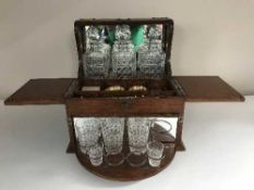 A Victorian oak three decanter tantalus and bridge box