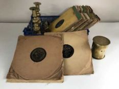 A box of 78's, pair of candlesticks, brass shell casing,