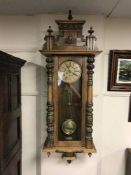 A late Victorian wall clock with pendulum and key