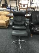 A contemporary black leather swivel recliner chair and matching footstool