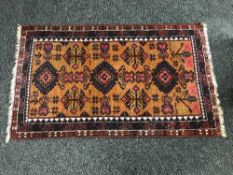 A fringed woolen Persian rug on red ground